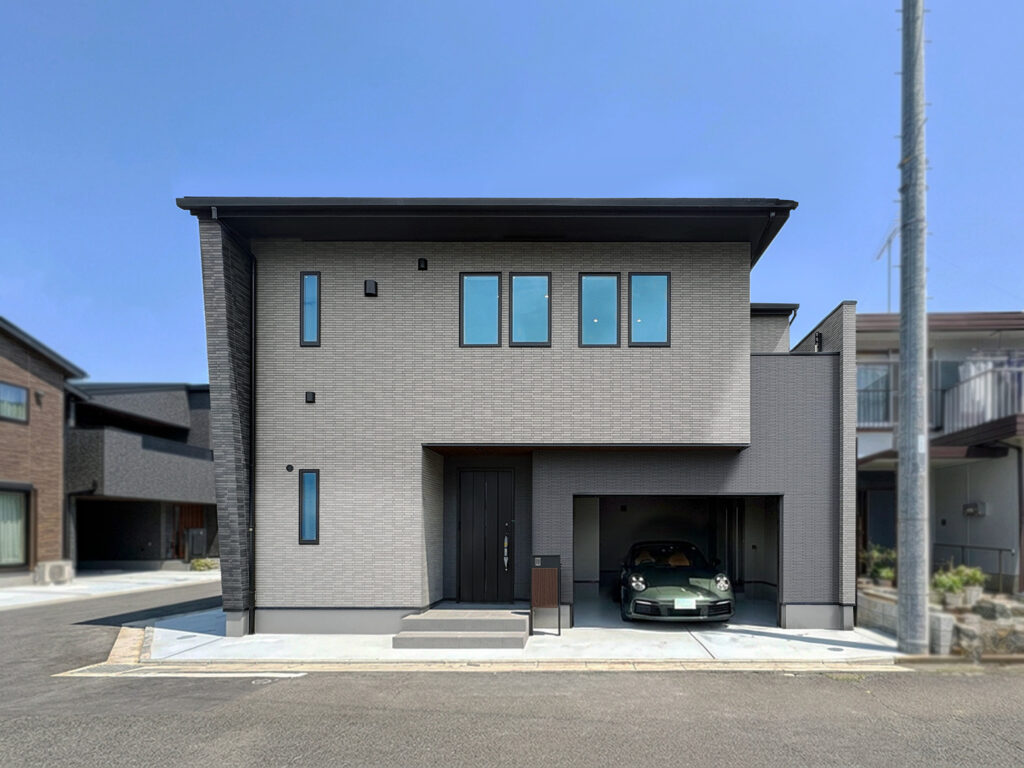 重厚感ある総タイル貼りの外観。ガレージとともに上質な時間を愉しむ住まい。